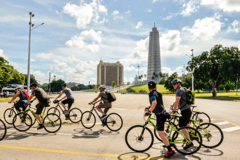 Group of travellers cycling around Plaza de La Revolución in Havana, Cuba