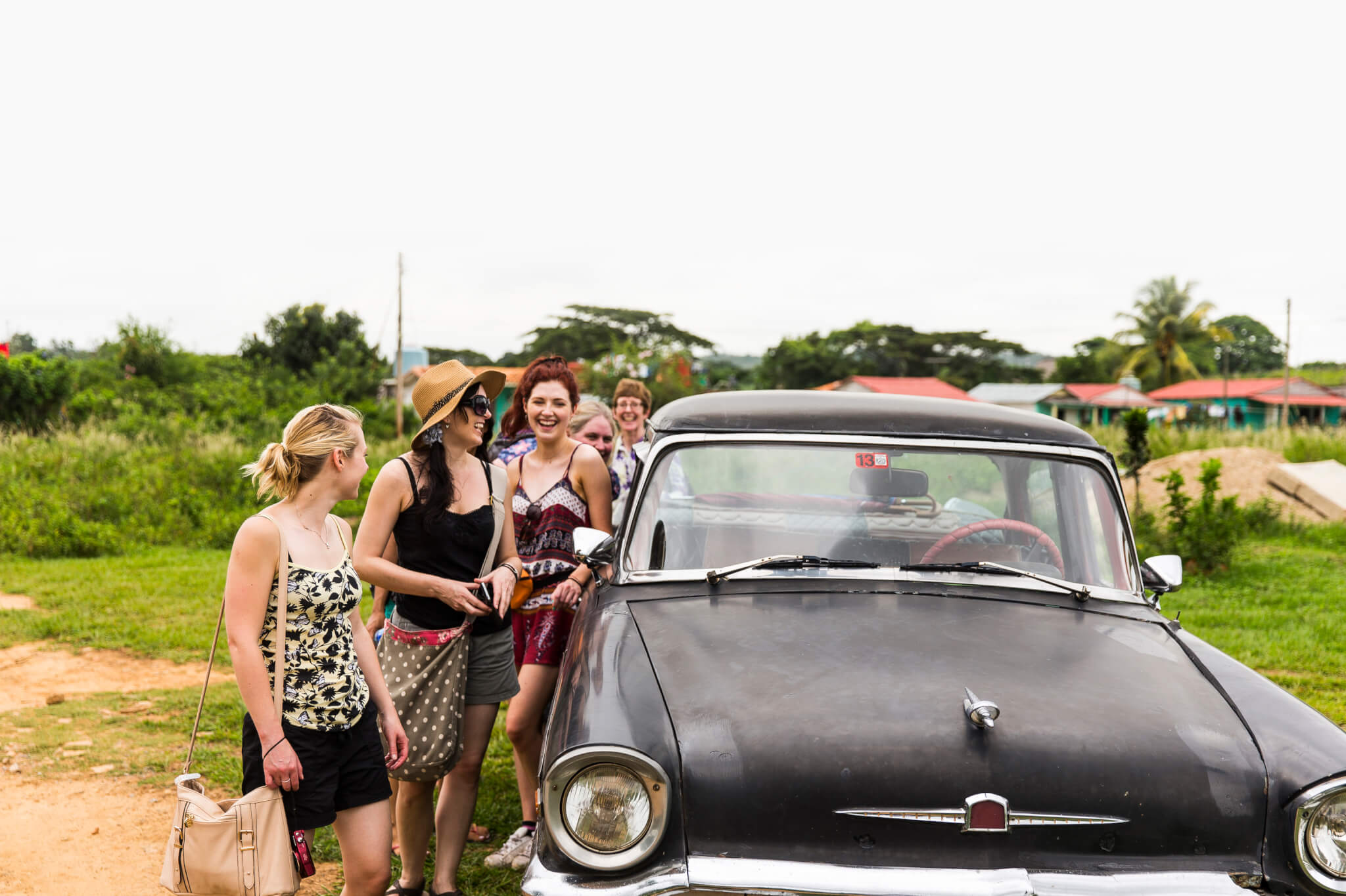 The Classic Cubania Experience, A Group of Young Women by a Classic American Car in Viñales, Cuba