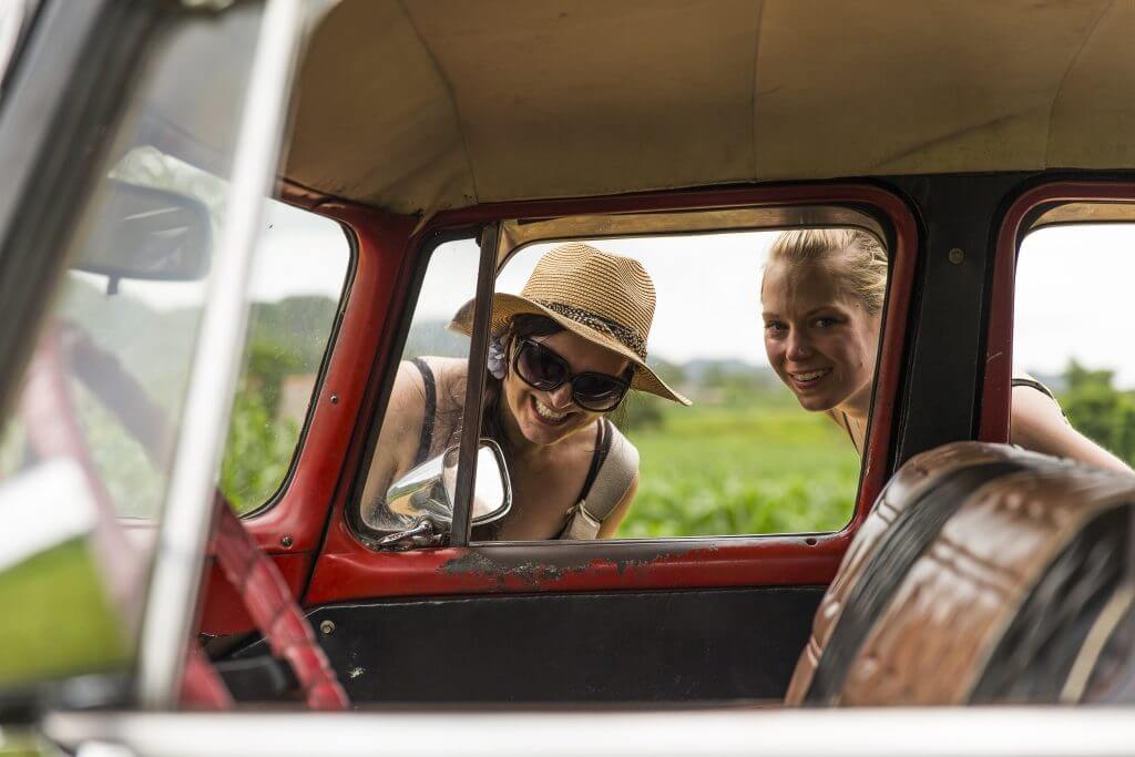 Young girls looking into Classic Vintage car, Cuba