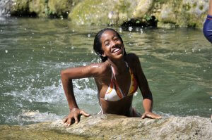 Young girl swimming in El Rocio Waterfall, Cuba