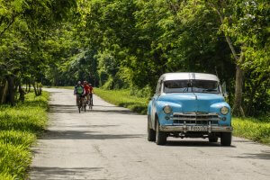 Cycling Group in Rural Cuba along with Classic American Car